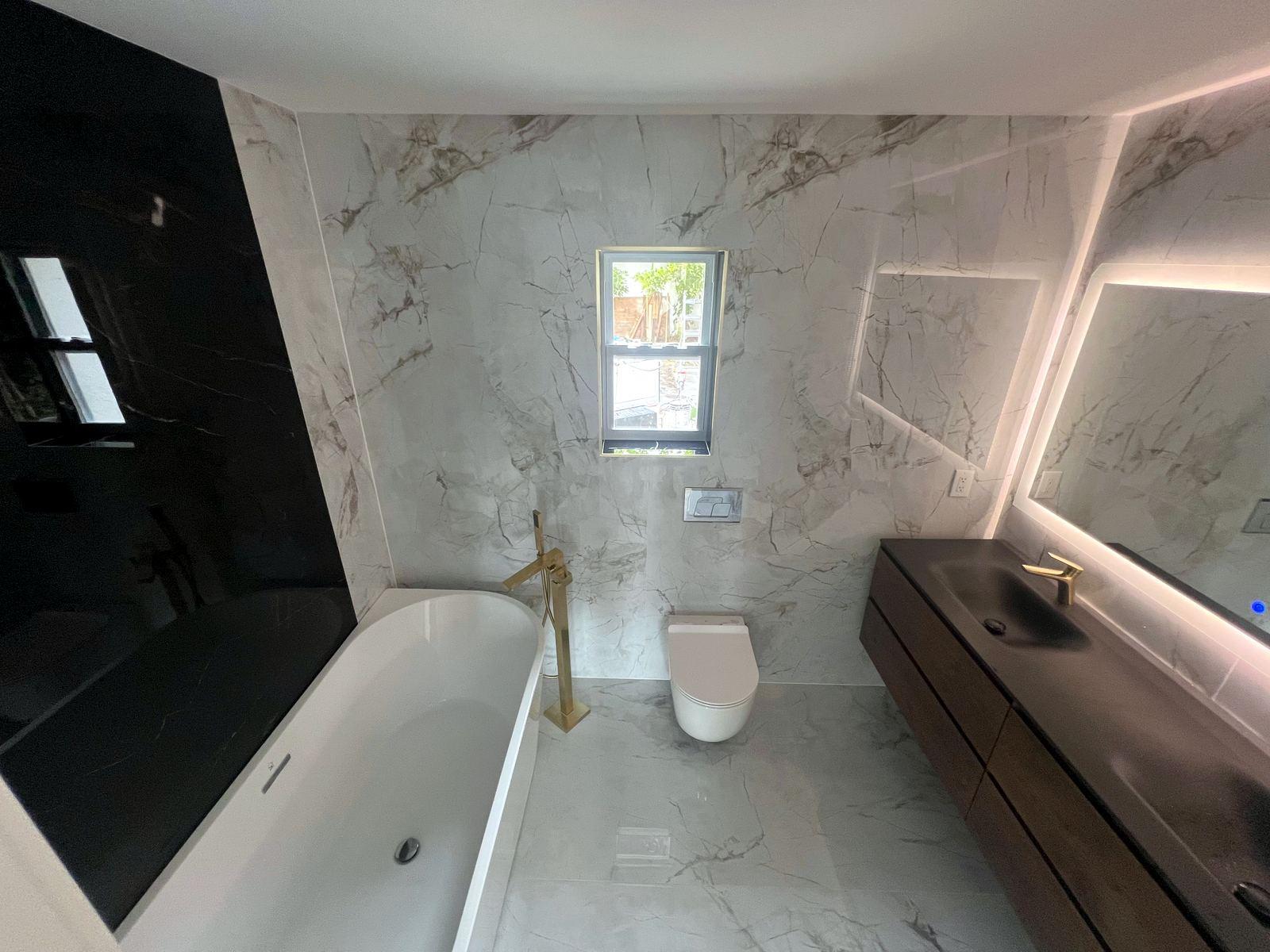 Finished bathroom remodel in marble-look porcelain with a freestanding tub