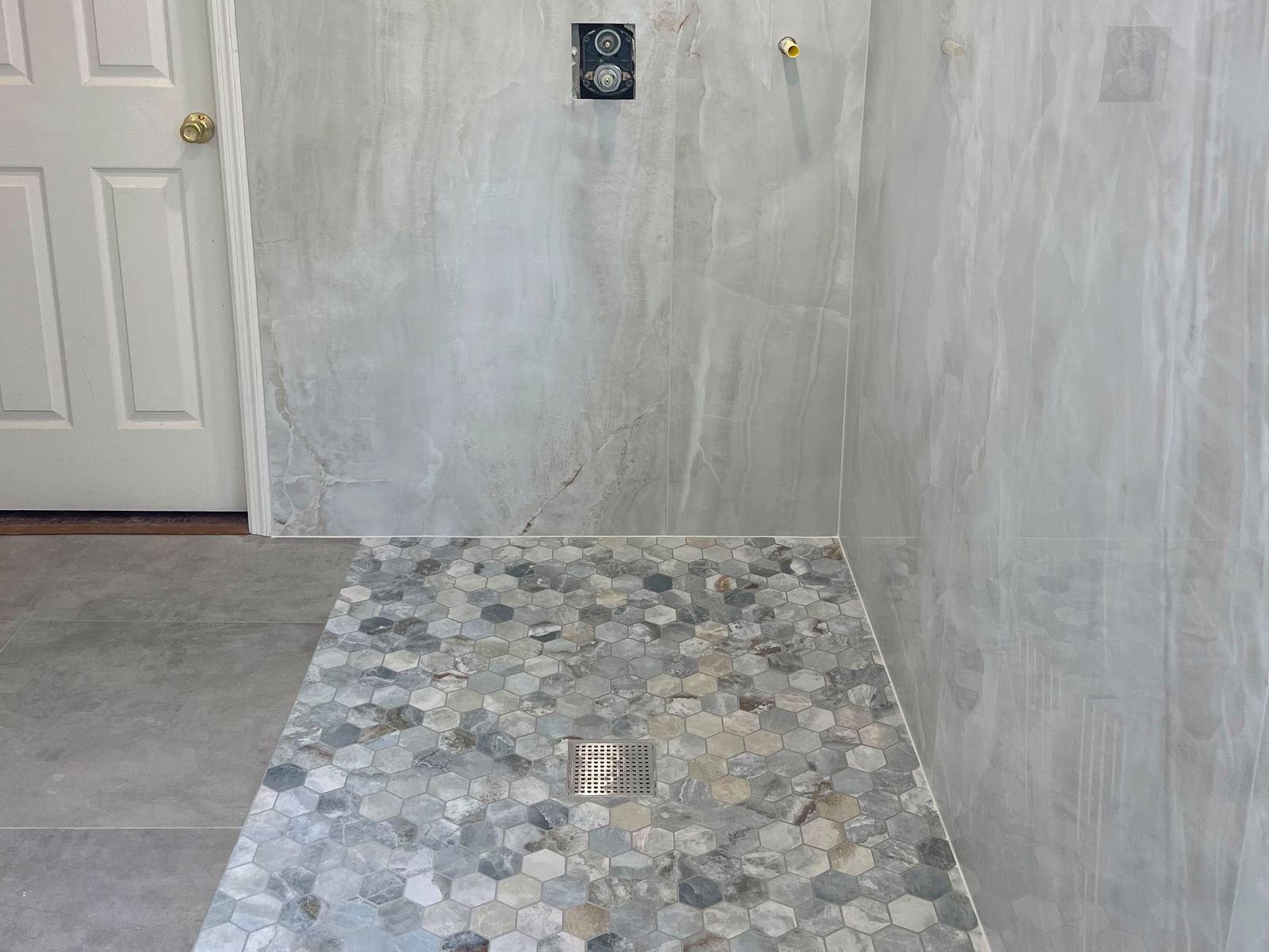 Rebuilt shower in large-format marble-look porcelain with a hexagon stone pan