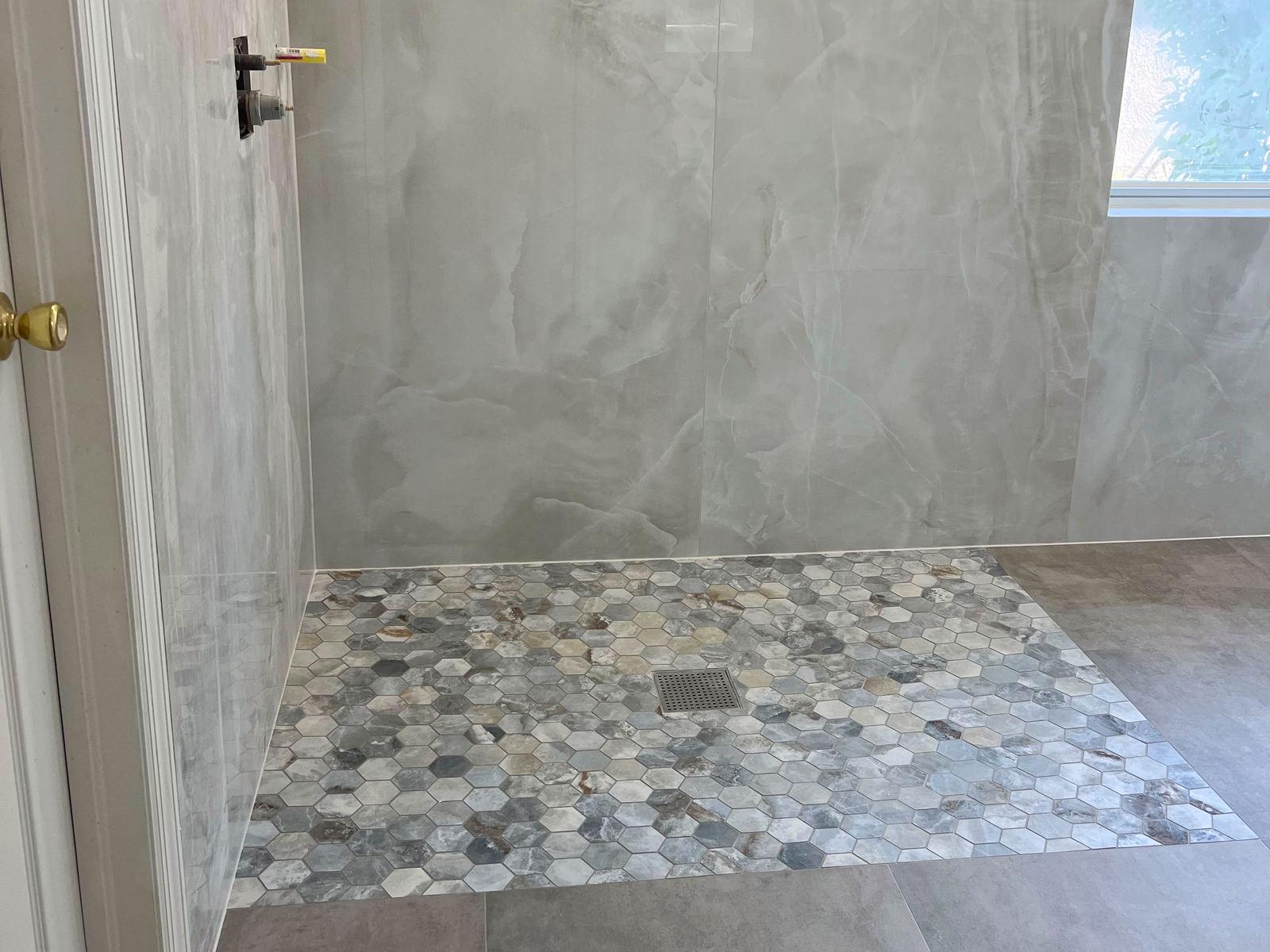 Curbless shower floor running flush into the bathroom tile, no step